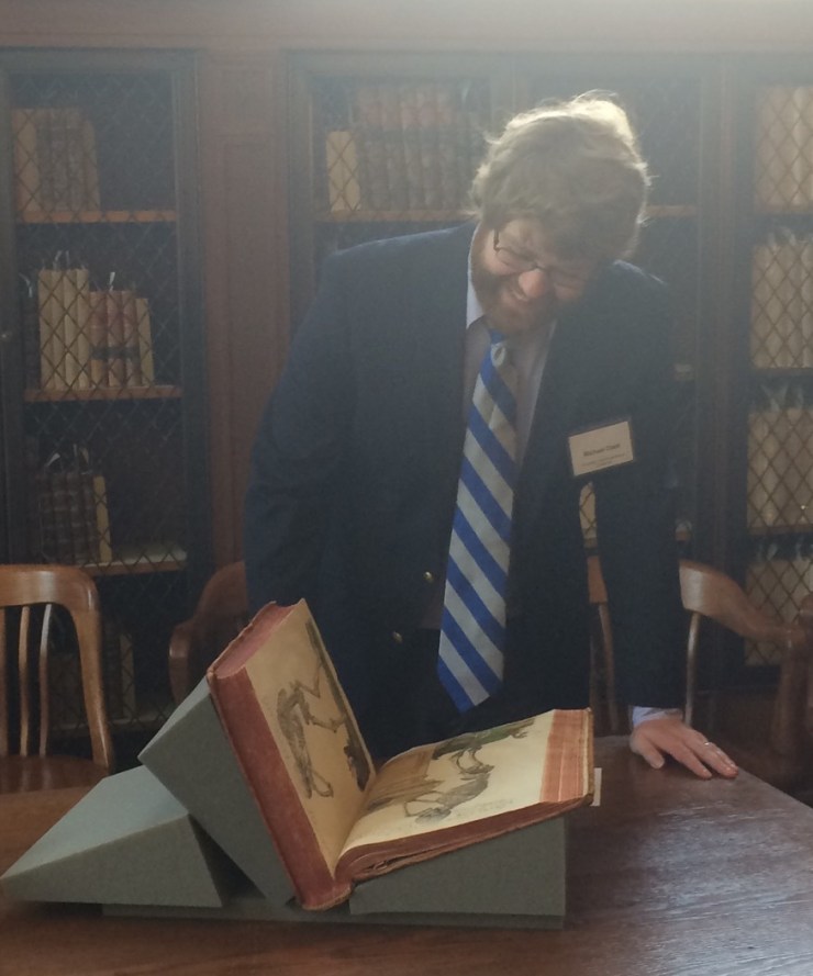 Michael examining illustrations in a rare book.